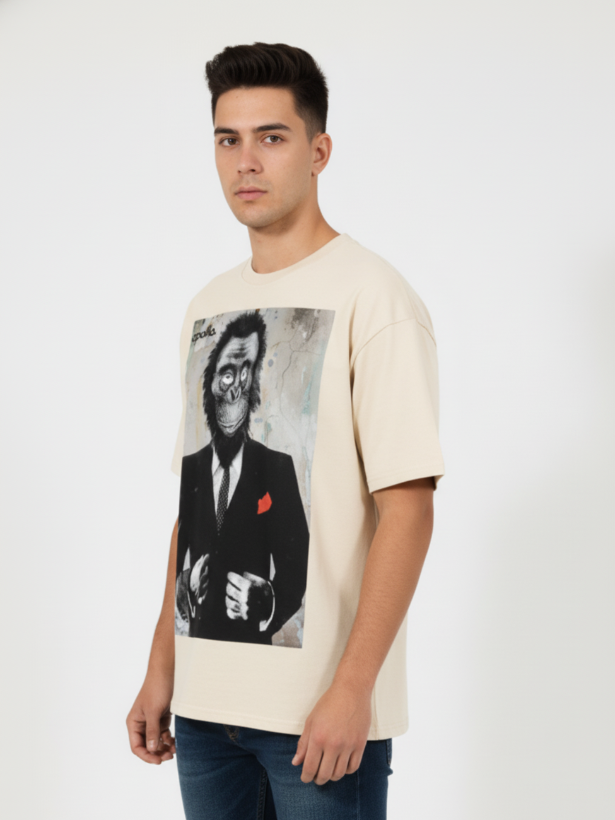 Man wearing a cream t-shirt with a graphic of a monkey in a suit on a white background