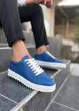 Blue sneakers with white soles worn on a step