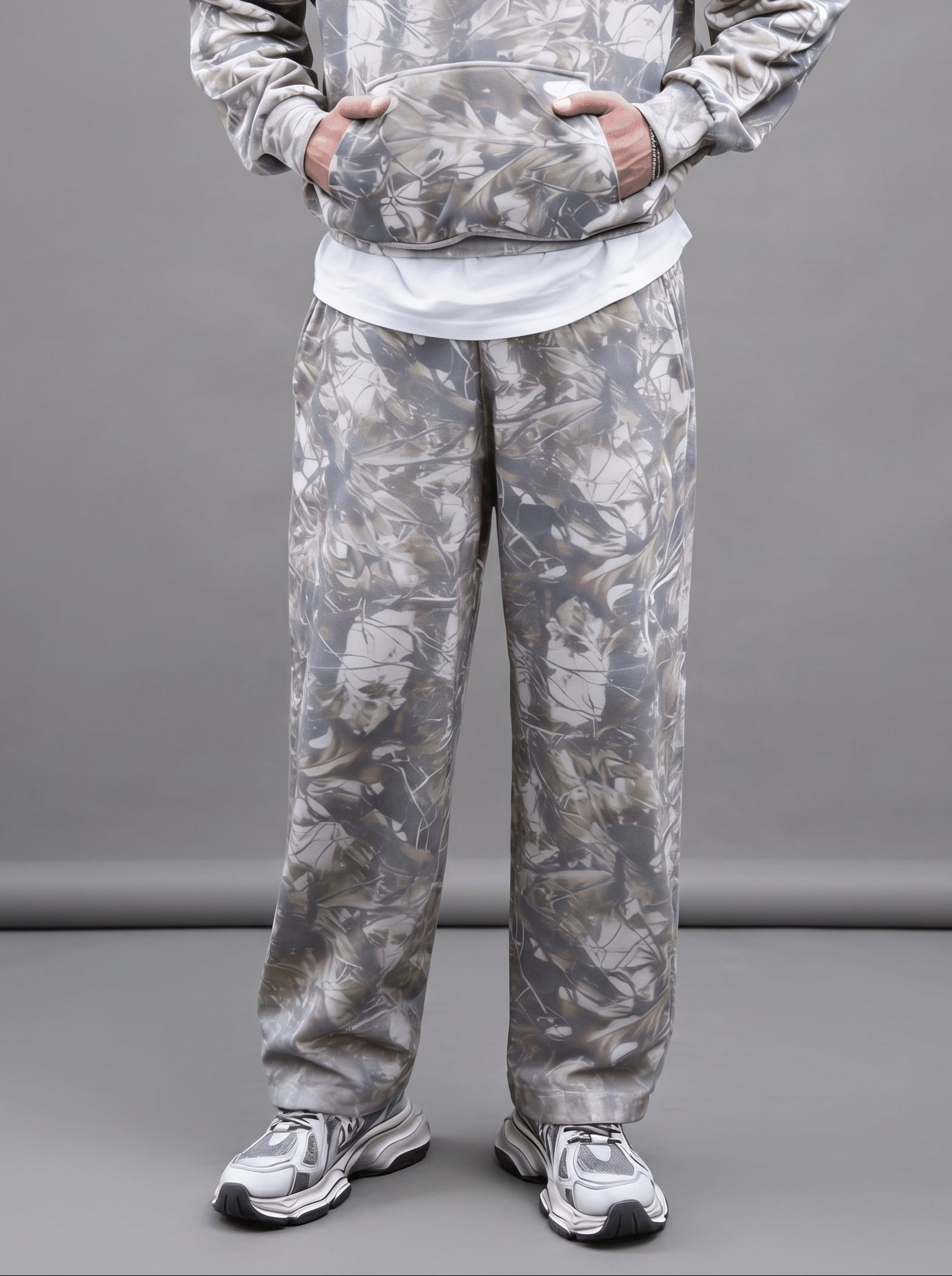 Person wearing a camouflage tracksuit on a gray background