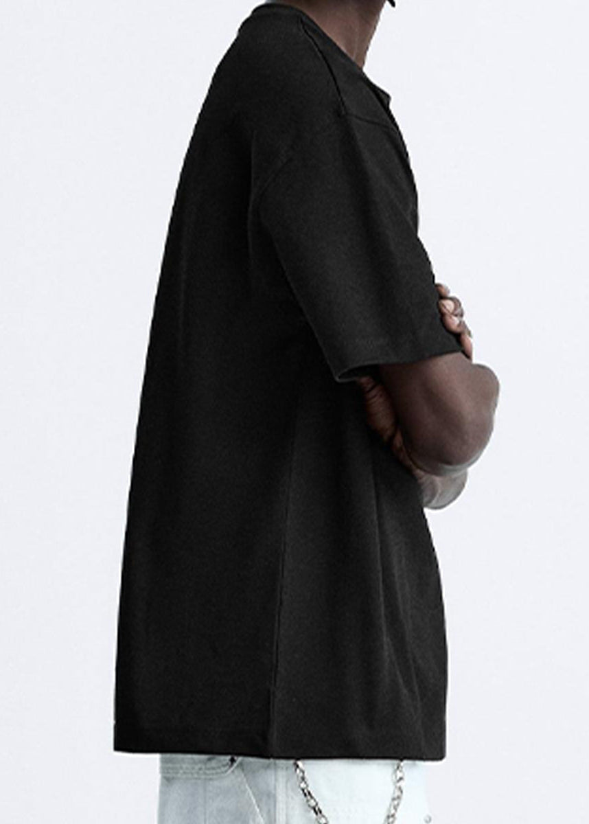 Person wearing a black shirt with rolled-up sleeves on a white background