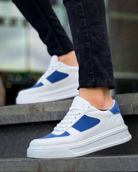 White sneakers with blue accents worn by a person on steps.