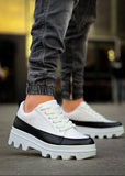 White sneakers with black accents worn by a person on a blurred background