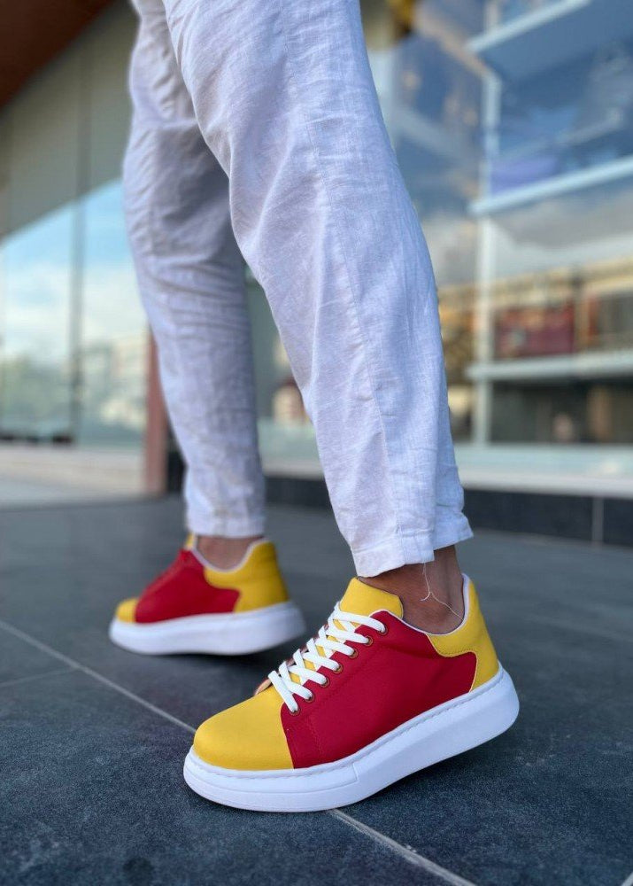 Red and yellow sneakers worn on a person's feet with a blurred background