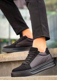 Black sneakers worn on a blurred outdoor background