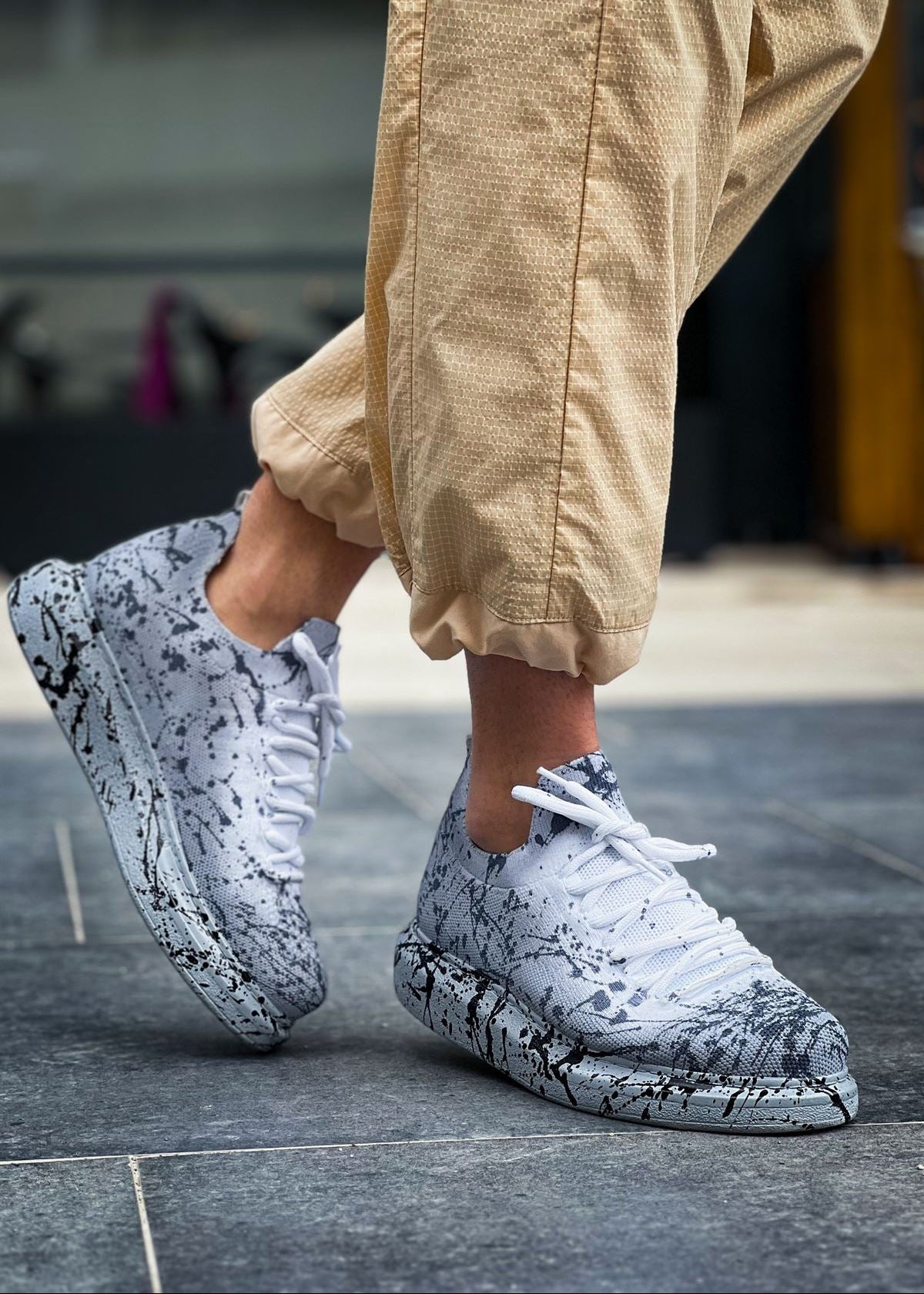 White and grey knit Torino Splatter Grey sneakers with black paint-splatter design and cushioned sole.
