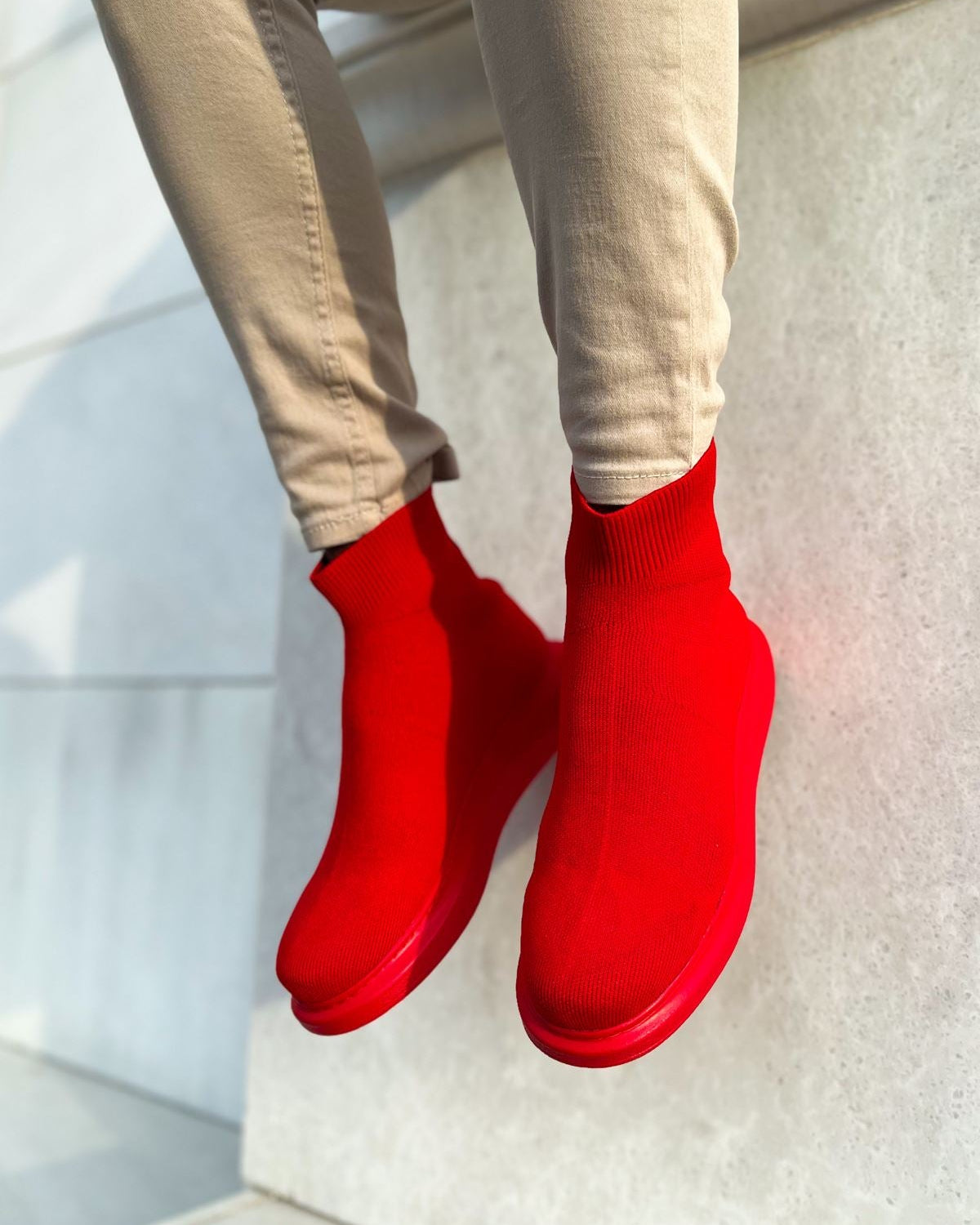 A pair of red ankle mesh Apollo Moda boots worn by a person against a light background.