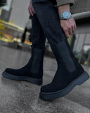 Lifestyle shot of Zenith Midnight Chelsea Boots by Apollo Moda in black suede with matching elastic panels and thick black soles.